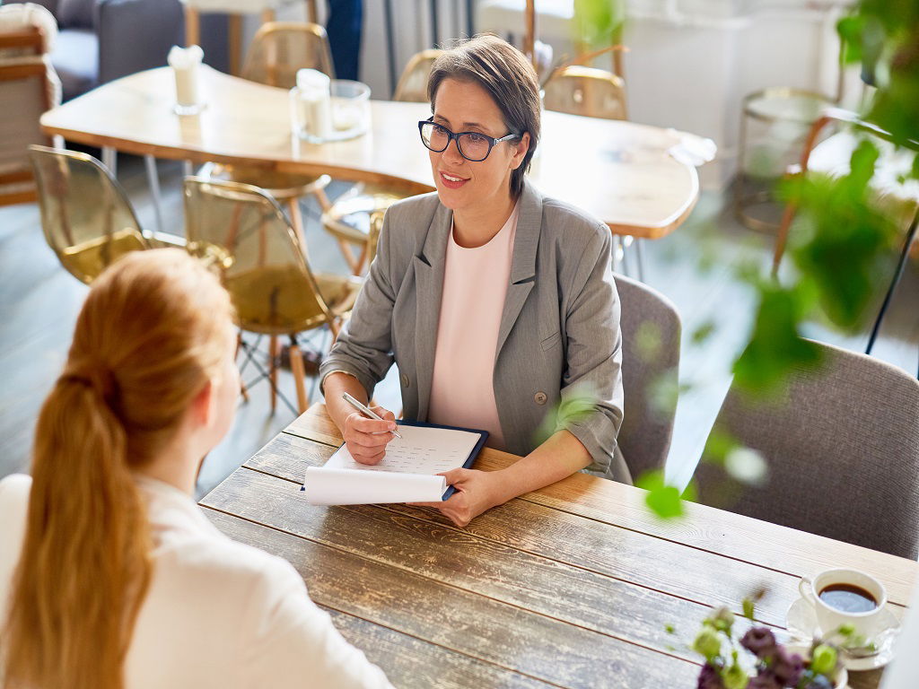 Confident image consultant woman hiring young specialist